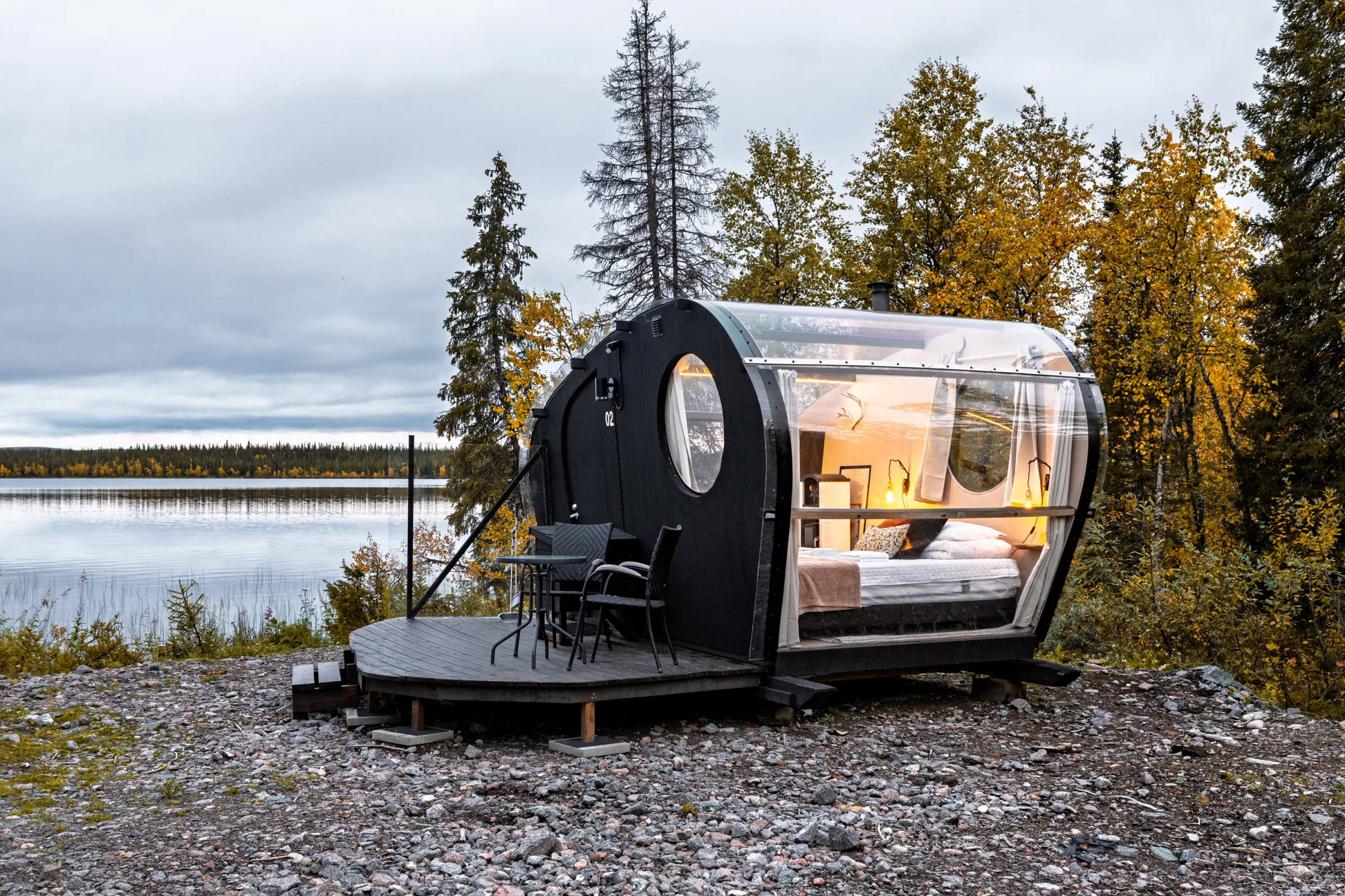 Glass cabin exterior beside the lake