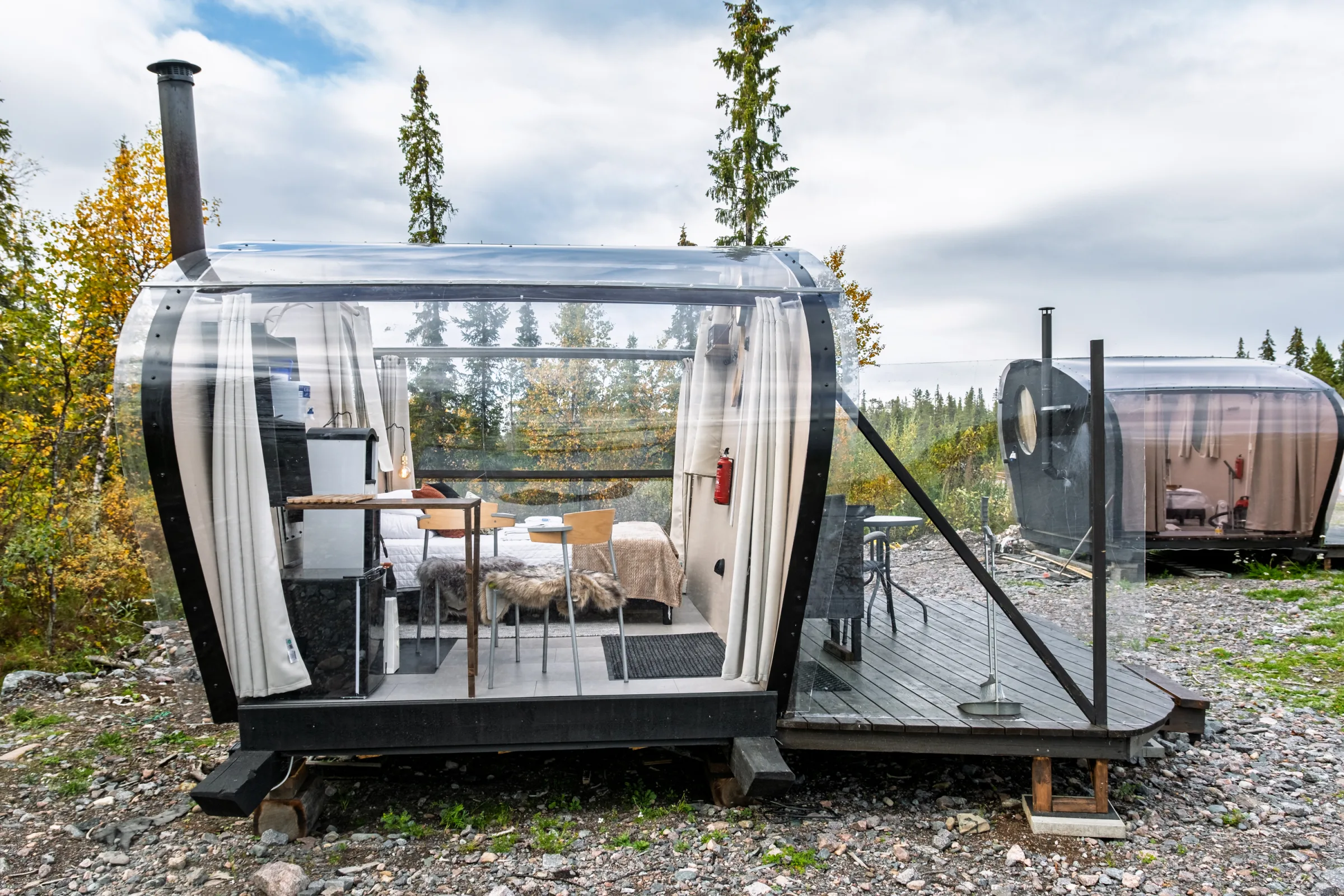Glass cabin exterior with the terrace and sauna behind